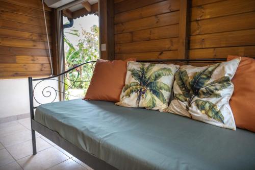 a bed with two pillows on it in a room at Gites villa bagatelle piscine et Plage à 900m in Sainte-Rose