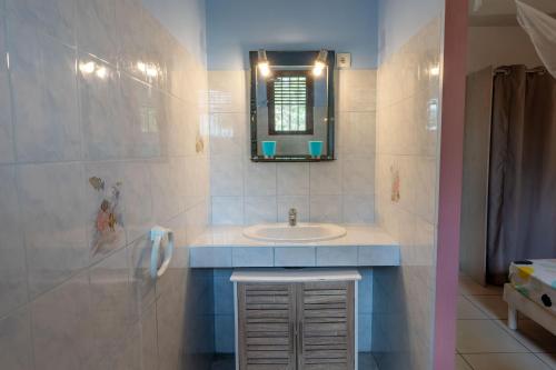 a bathroom with a sink and a mirror at Gites villa bagatelle piscine et Plage à 900m in Sainte-Rose