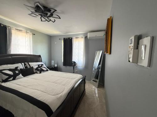a bedroom with a bed and a ceiling fan at Elysium Noire in Spanish Town