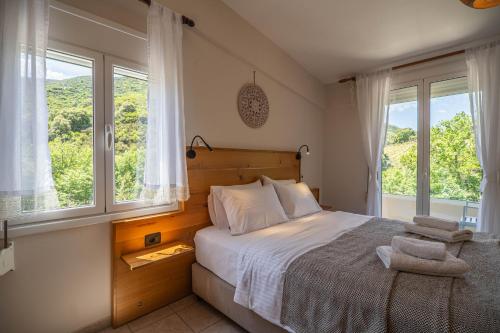 a bedroom with a large bed with two windows at Villa 4 DESTINA in Élos