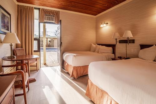 a hotel room with two beds and a table at The Guv'nor Inn & Pub in St. John's