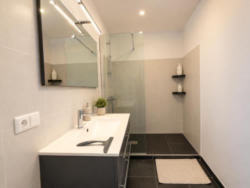 a bathroom with a sink and a mirror at Sea Road Perpignan in Perpignan