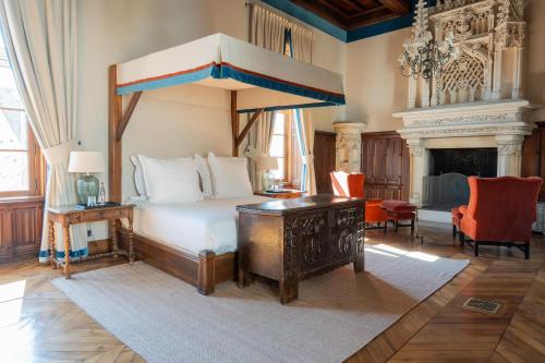a bedroom with a canopy bed and a desk at Château Sainte Sabine in Sainte-Sabine