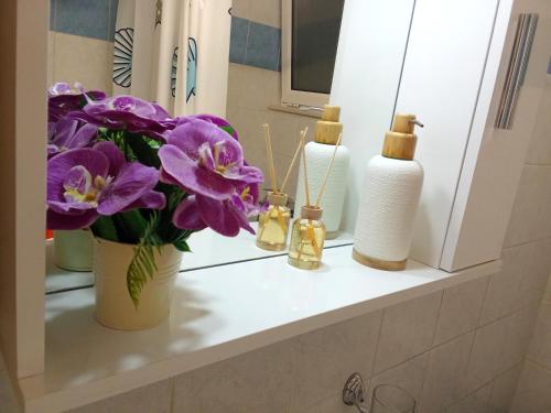 a bathroom counter with flowers and candles on it at Kyma studio Modern Stay in Nea Artaki
