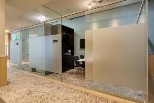 an office with glass walls and a table in a room at Radisson Hotel Brussels Centre Midi in Brussels