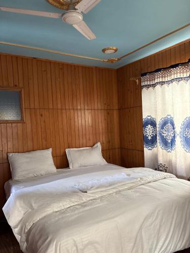 a bedroom with a large white bed with a window at Giggle in Srinagar