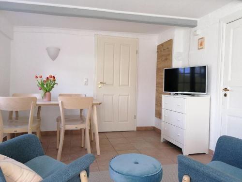 a living room with a table and a tv at Urlaub mit Hund - aktuell noch freie Kapazitäten im Sommer! in Riepsdorf