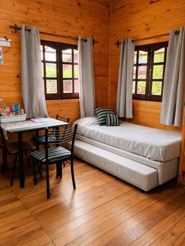 a bedroom with two beds and a table in a cabin at Monoambiente D'Charruas in Chajarí