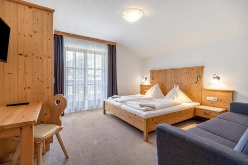 a bedroom with a bed and a desk and a couch at Appartements Stockinger B4 in Grossarl