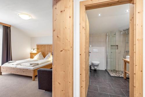 a bedroom with a bed and a bathroom with a shower at Appartements Stockinger B4 in Grossarl