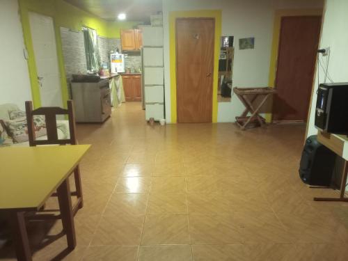 a kitchen and a living room with a wooden floor at Los patos in Capilla del Monte