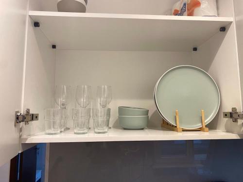a shelf with glasses and a mirror on it at ZAZA Apartament - central area, with balcony in Târgu Jiu