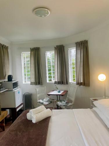 a bedroom with a large white bed and a desk at Kelp Cottage - Two Private Garden en-suite Rooms in Gansbaai