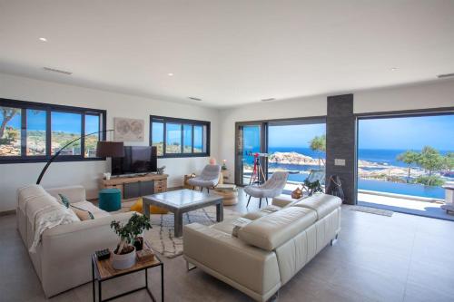 a living room with a couch and a tv and some windows at Villa Bianca in LʼÎle-Rousse
