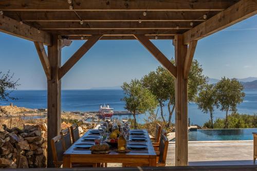 a long wooden table with a view of the ocean at Villa Bianca in LʼÎle-Rousse