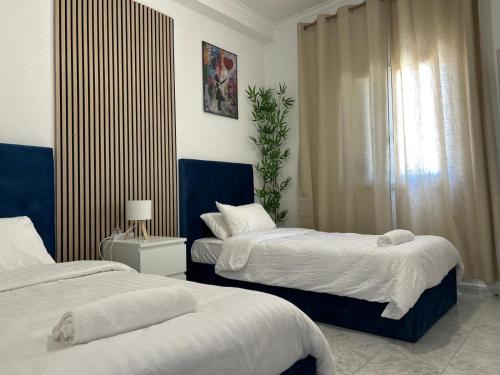 a bedroom with two beds and a window at ABRA residence alverca in Quinta da Verdelha
