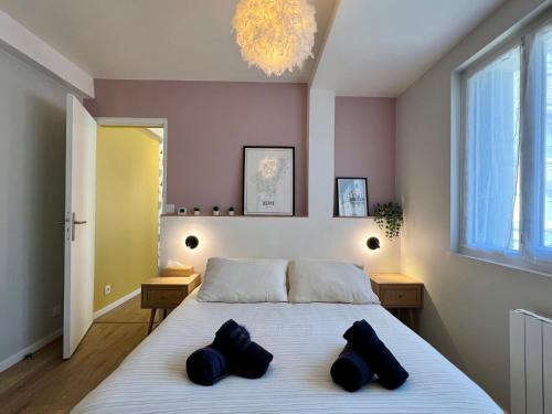 a bedroom with a bed with two black pillows on it at La Cabine ménage et linge inclus in Dieppe