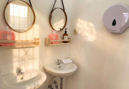 a bathroom with two mirrors and a sink at Decasa Female House in Malang