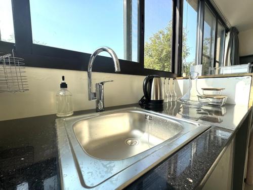 a kitchen counter with a sink and a window at Shakti, Abdelli guesthouse in Batroûn