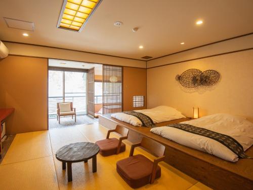 a bedroom with a bed and a table and a chair at Iwaiyado Jyuan Nikko Kawaji onsen in Nikko