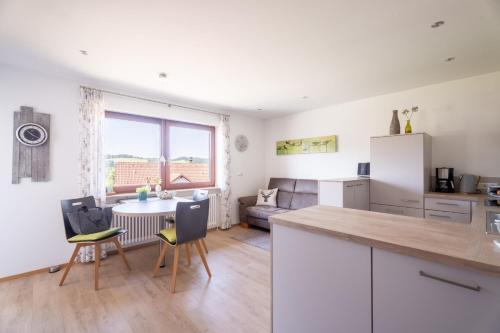 a kitchen and living room with a table and chairs at Hofquartier in Kappelrodeck