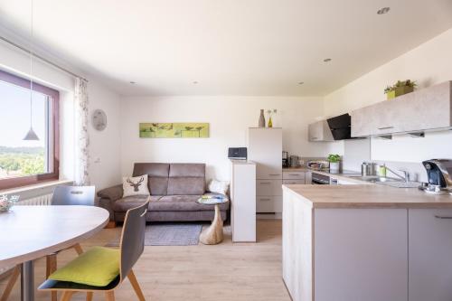 a kitchen and living room with a couch and a table at Hofquartier in Kappelrodeck