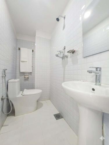 a white bathroom with a sink and a toilet at Hotel In N Out in Kathmandu