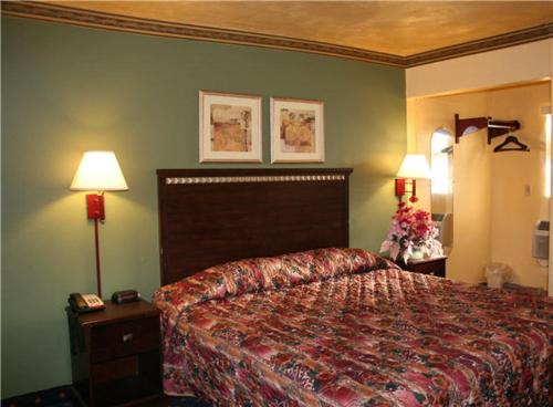a hotel room with a bed and two lamps at Plaza Travel Inn in Clewiston
