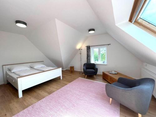 a attic bedroom with a bed and a chair at Haus-Min-Leevstes in Böhl