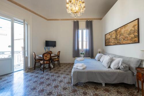 a bedroom with a bed and a table and a chandelier at Chez Moi in Trapani