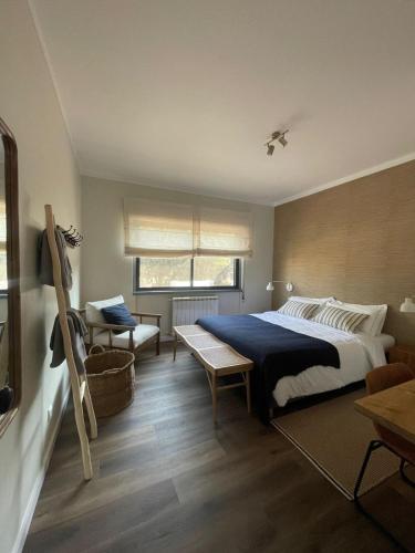 a bedroom with a bed and a chair and a table at Monte da Fonte in Odemira