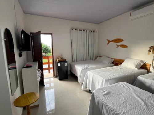 a hotel room with two beds and a television at Pousada Viva Santo Amaro in Santo Amaro