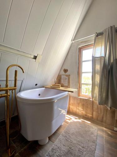a white bath tub in a bathroom with a window at Pousada Sítio Bosque in Campina Grande
