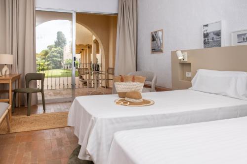 a hotel room with a bed with a hat on it at RVHotels Golf Costa Brava in Santa Cristina d'Aro