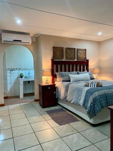 a bedroom with a bed and a bathroom with a sink at Golf View Lodge Melmoth in Melmoth