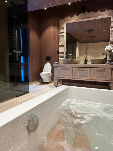 a bathroom with a tub with a toilet and a sink at Stor hytte på Gaustablikk in Gaustablikk