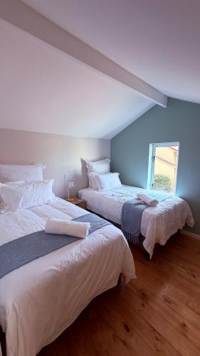 a bedroom with two beds and a window at Sunset Beach Self-Catering in Marina da Gama