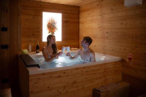 a man and a woman in a bath tub at Negritella Sweet Hotel in Ziano di Fiemme