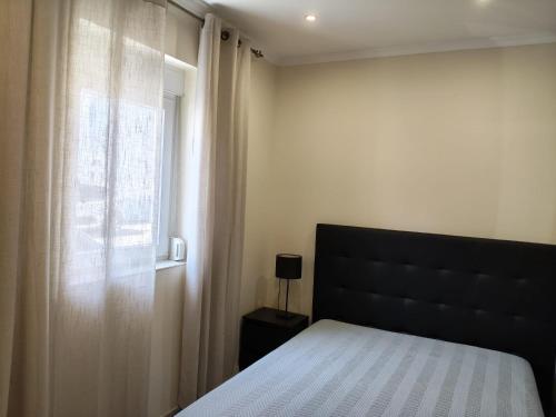 a bedroom with a bed and a window at Casa Verão Azul in Monte Gordo
