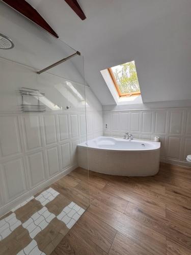 a large bathroom with a tub and a window at Dworek in Szonowice