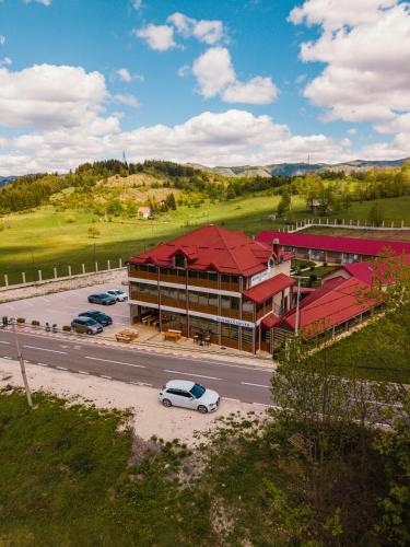 a building with a car parked in a parking lot at Hotel Sjever in Šavnik