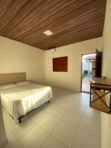 a bedroom with a bed and a wooden ceiling at Lotus Beach in Piaçabuçu