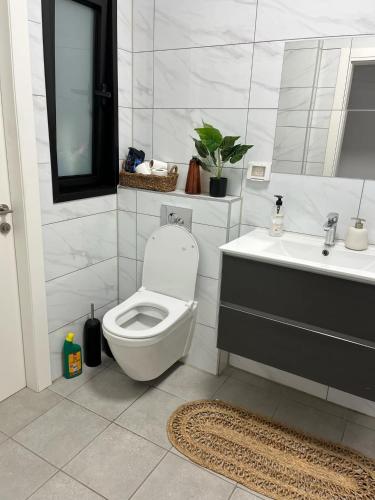 a bathroom with a toilet and a sink at amor premium residence-4BR apartment with balcony in Beer Sheva