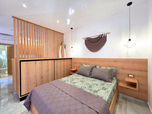 a bedroom with a bed and a wooden wall at Anthouli homes 4, steps from beach and centre in Kardamaina