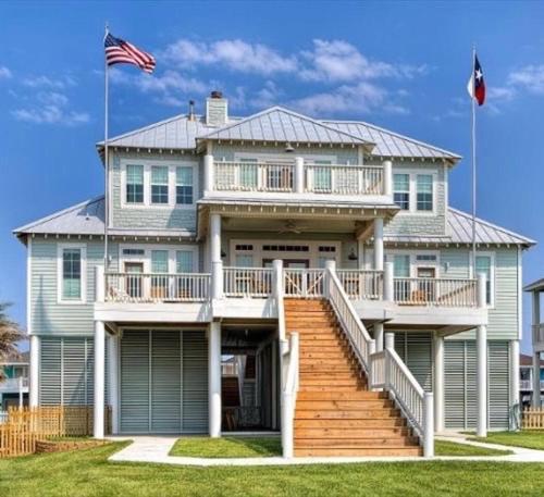a large house with a large porch and stairs at Moss Landing Luxury Beachfront Private Walkover in Bolivar Peninsula