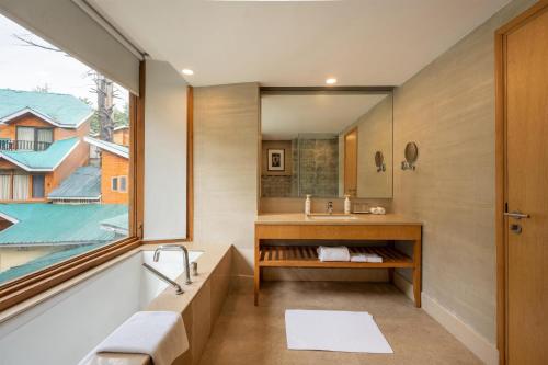 a bathroom with a sink and a mirror at Radisson Golf Resort Pahalgam in Pahalgām