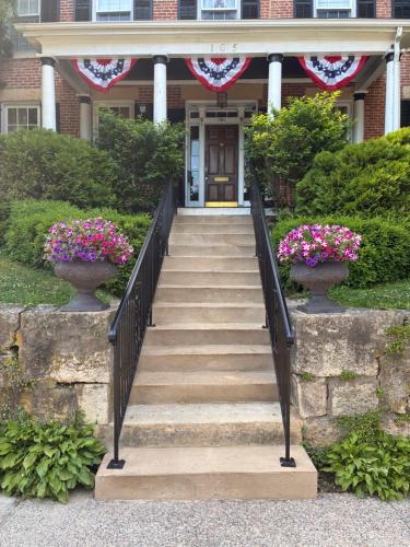 a staircase leading to a house with two vases with flowers at Miss Murphy's High Street Inn in Galena