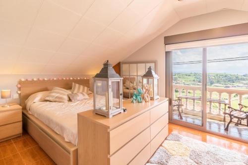 a bedroom with a bed and a balcony at La Centinela en Costa Quebrada in Miengo