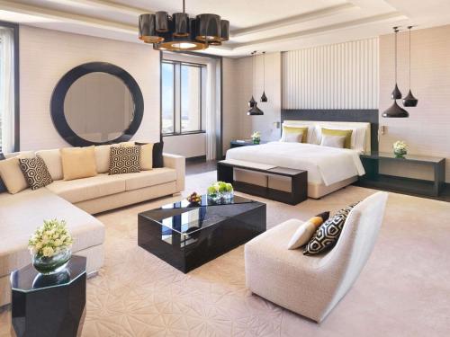 a hotel room with a bed and a living room at Fairmont Riyadh in Riyadh