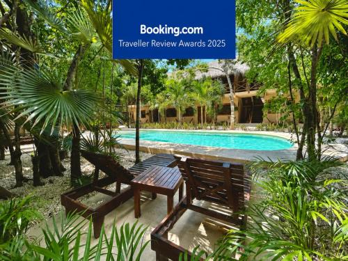 un resort con piscina e due panchine di Aldea Xaan Ha Tulum a Tulum